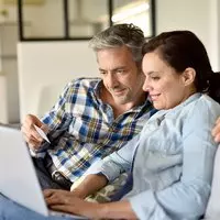 Older couple sitting with laptop