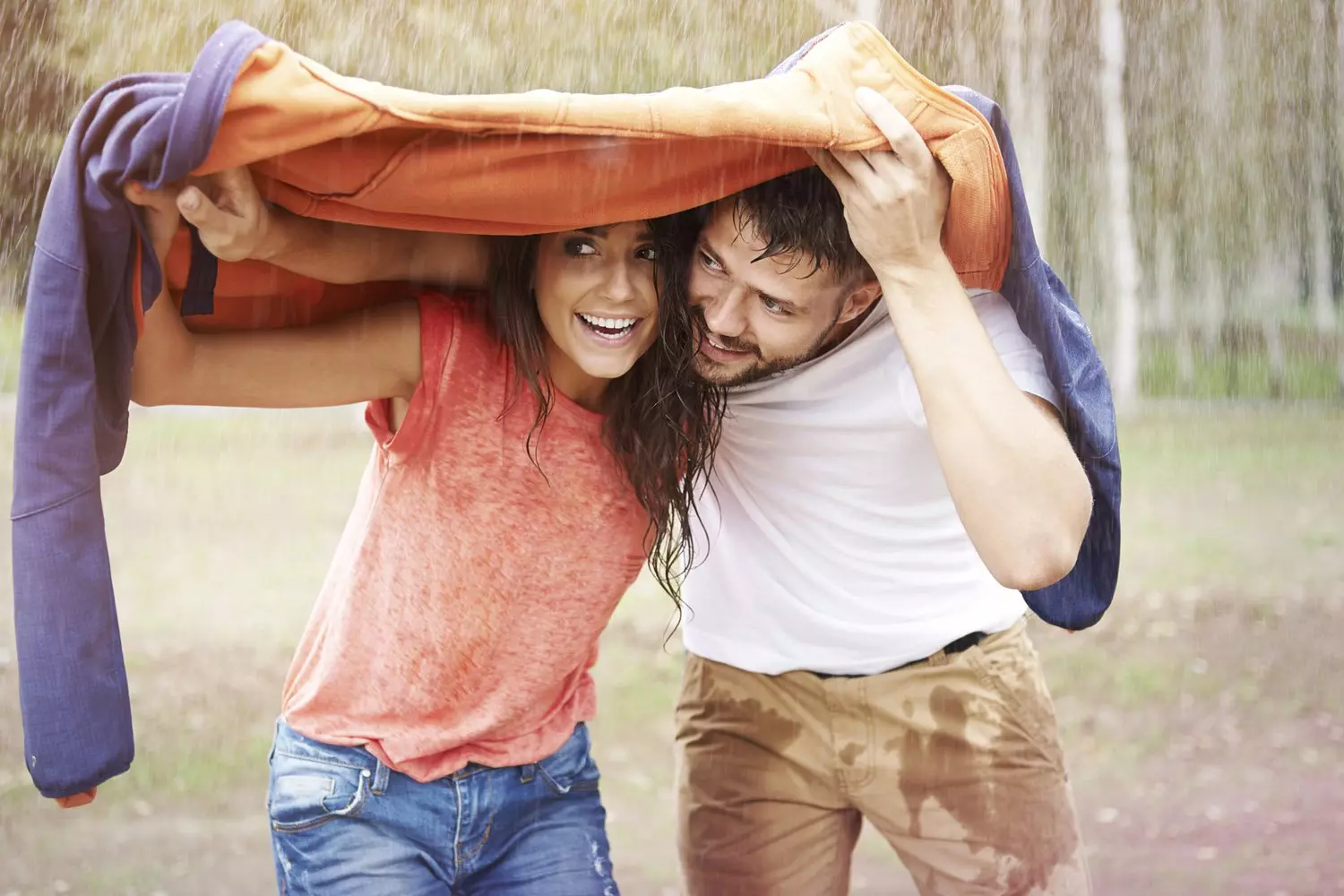 Couple shielding themselves from the rain with a jacket