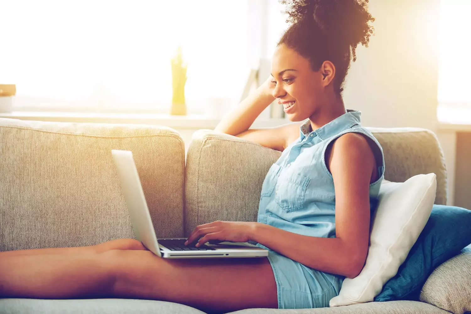Black woman using laptop on couch