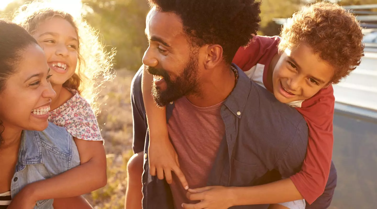 Black family - Mom and dad giving piggy back rides