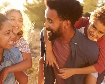 Black family - Mom and dad giving piggy back rides