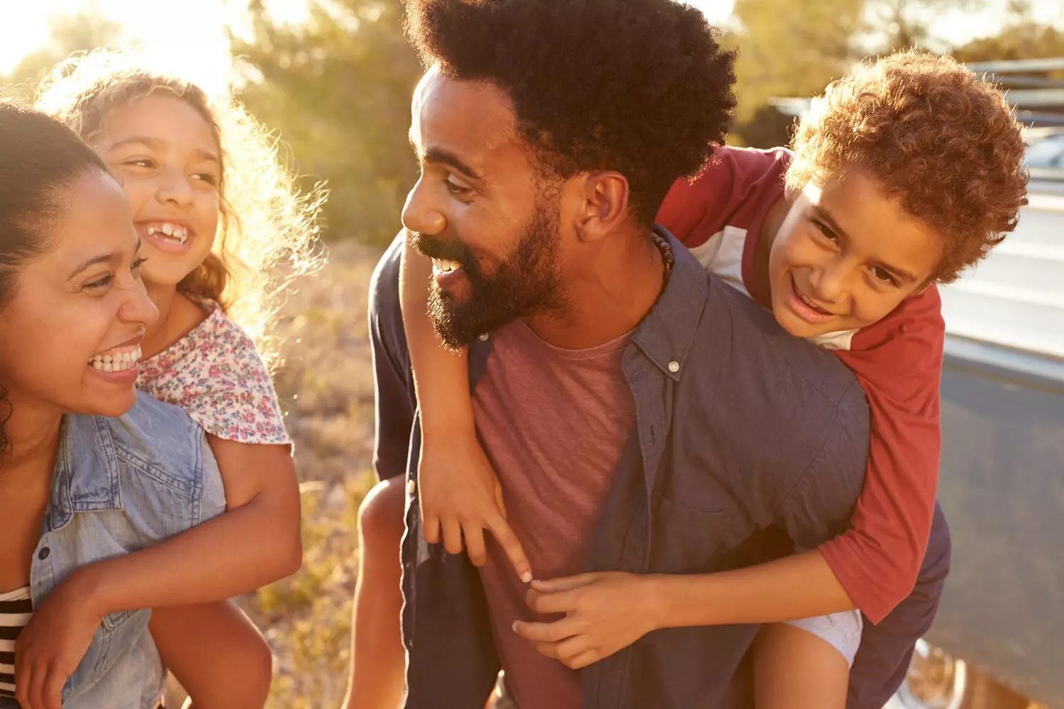 Black family - Mom and dad giving piggy back rides
