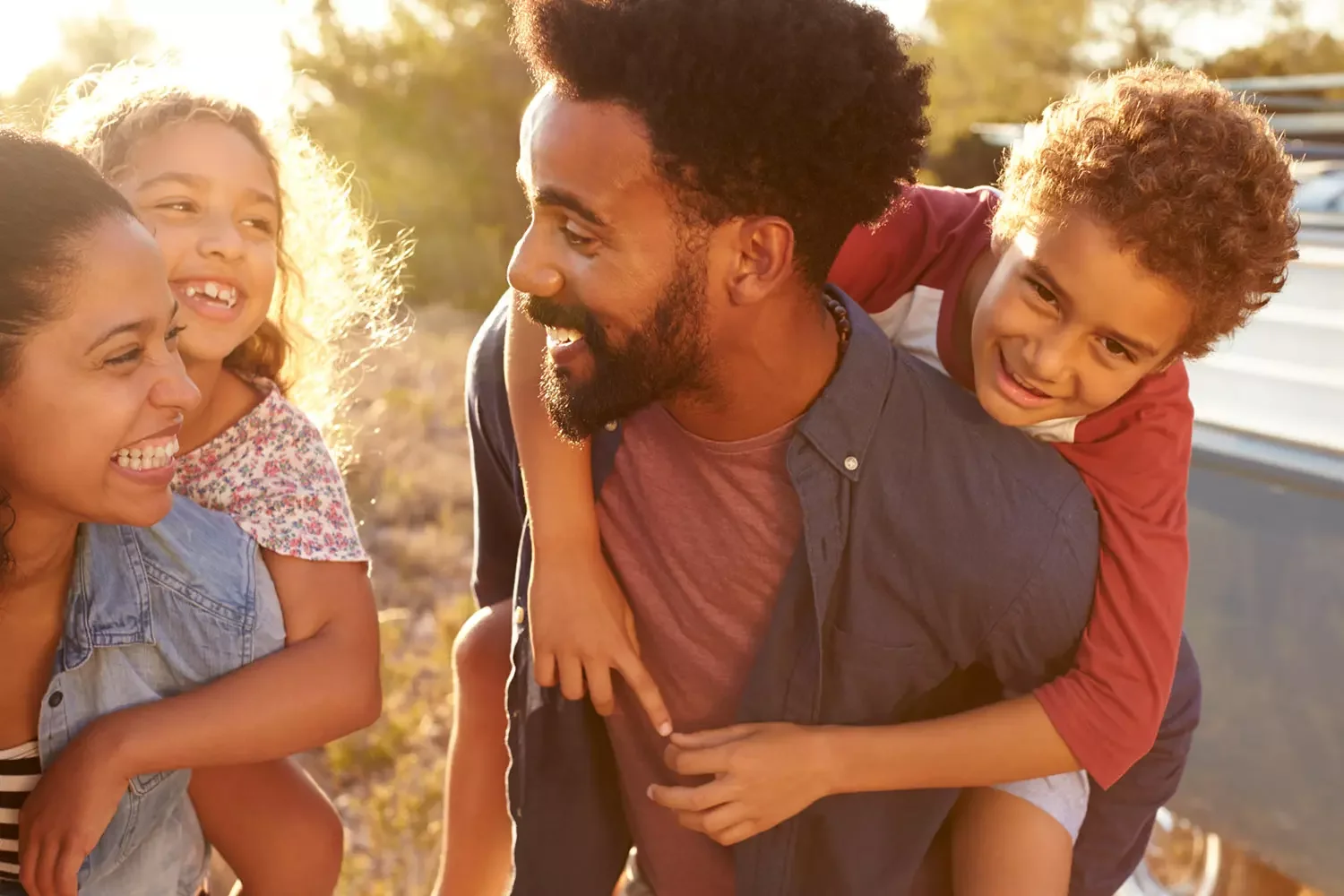 Black family - Mom and dad giving piggy back rides