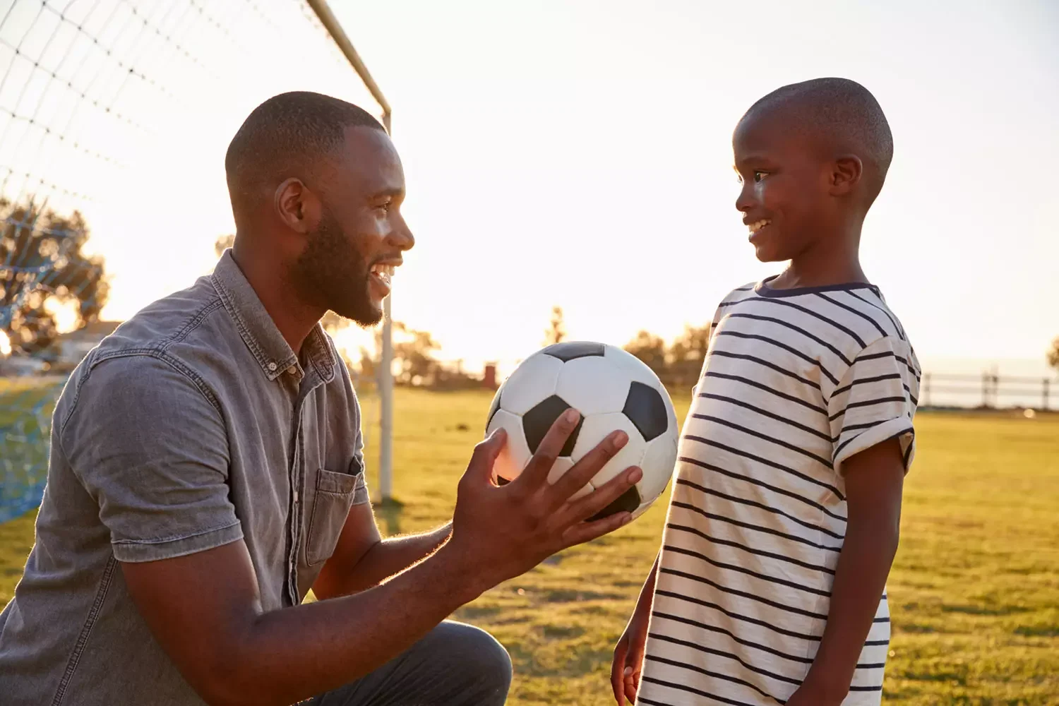 Black father and son playing soccer