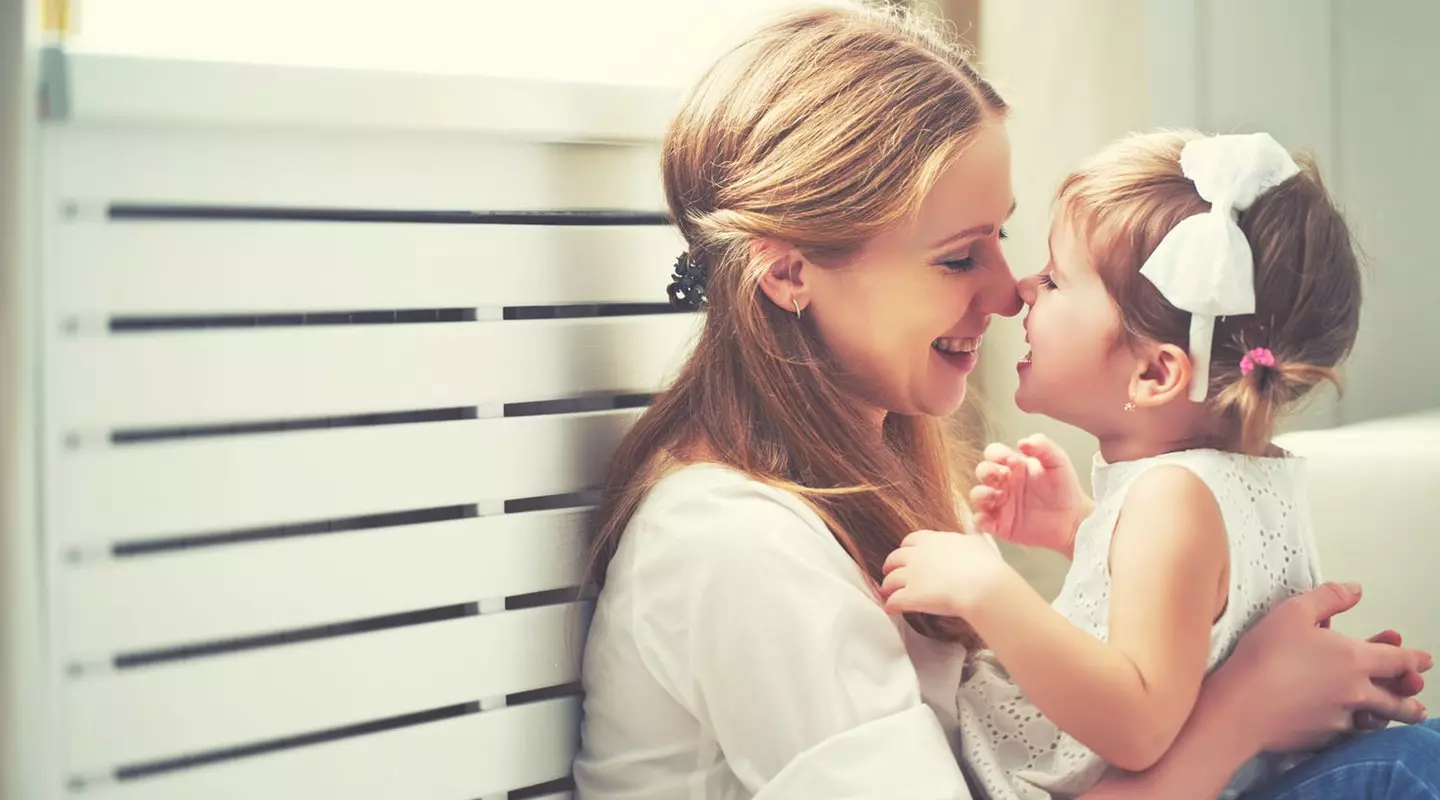 Mother hugging young daughter