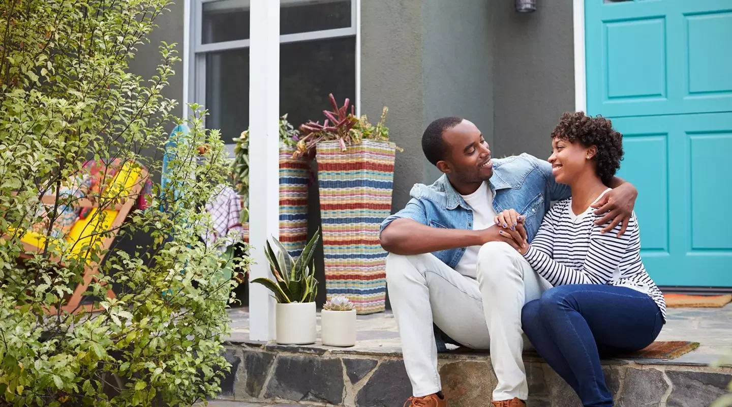 Black couple in front of home