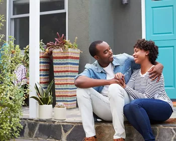 Black couple in front of home