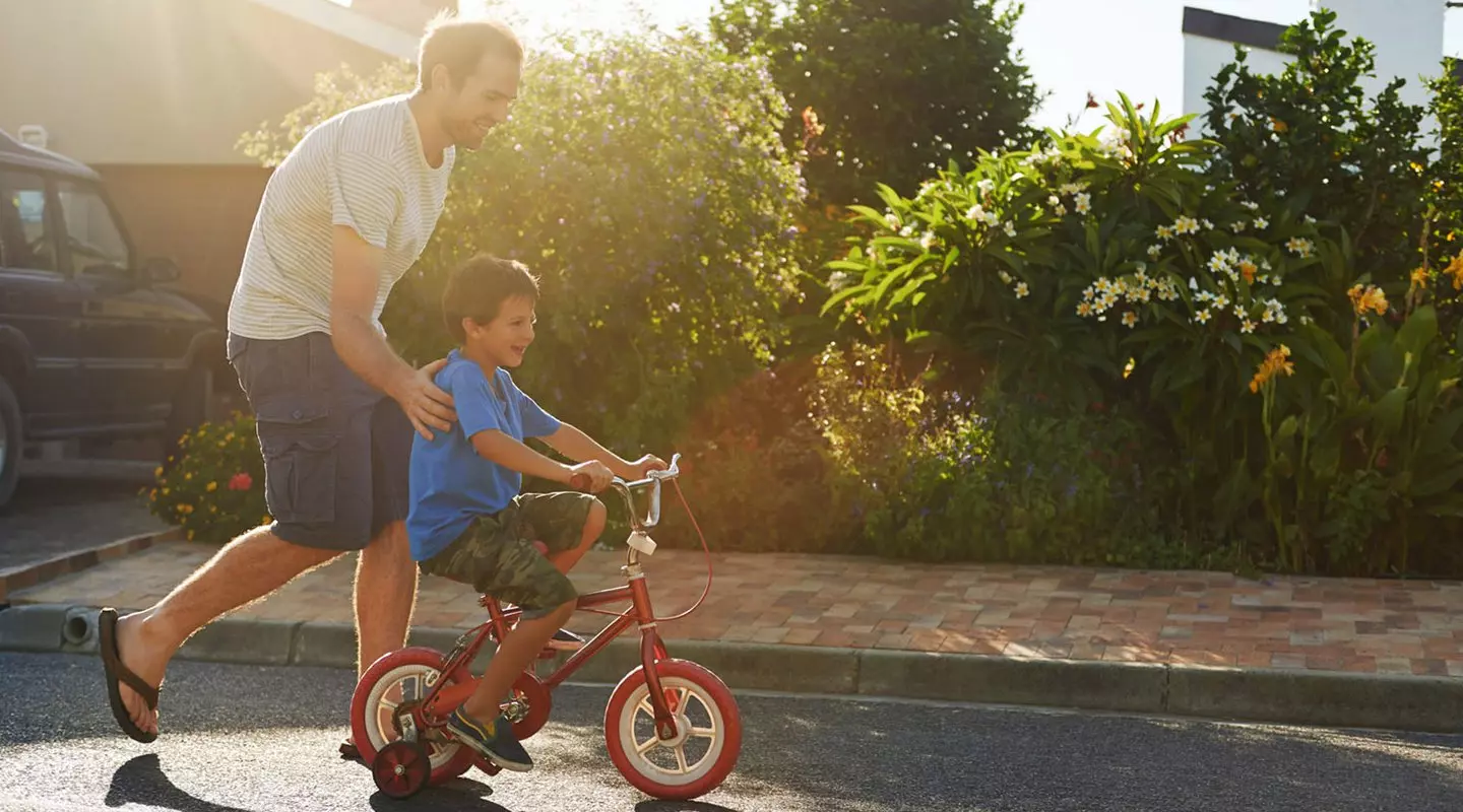 Father helping his son ride a bike