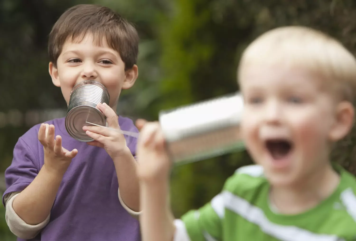 2 boys playing telephone with cans