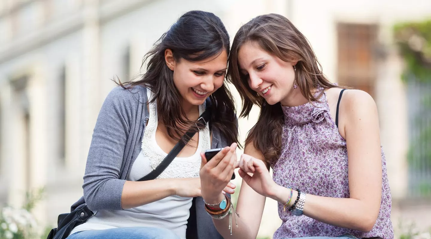 Two girls looking at their phone