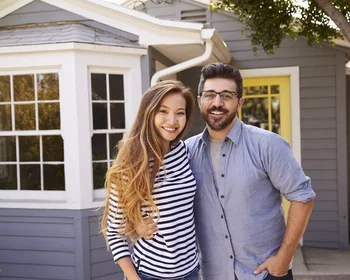 Couple standing in front of house