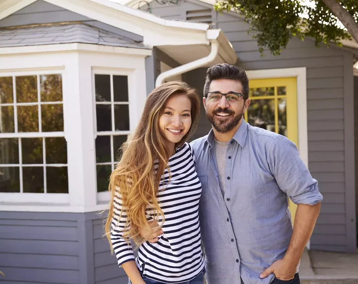 Couple standing in front of house