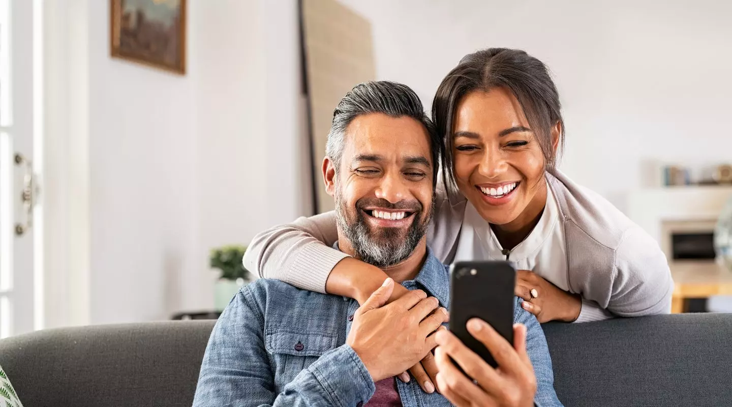 smiling couple looking at phone