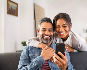 smiling couple looking at phone