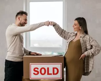 couple fist bumping over moving box