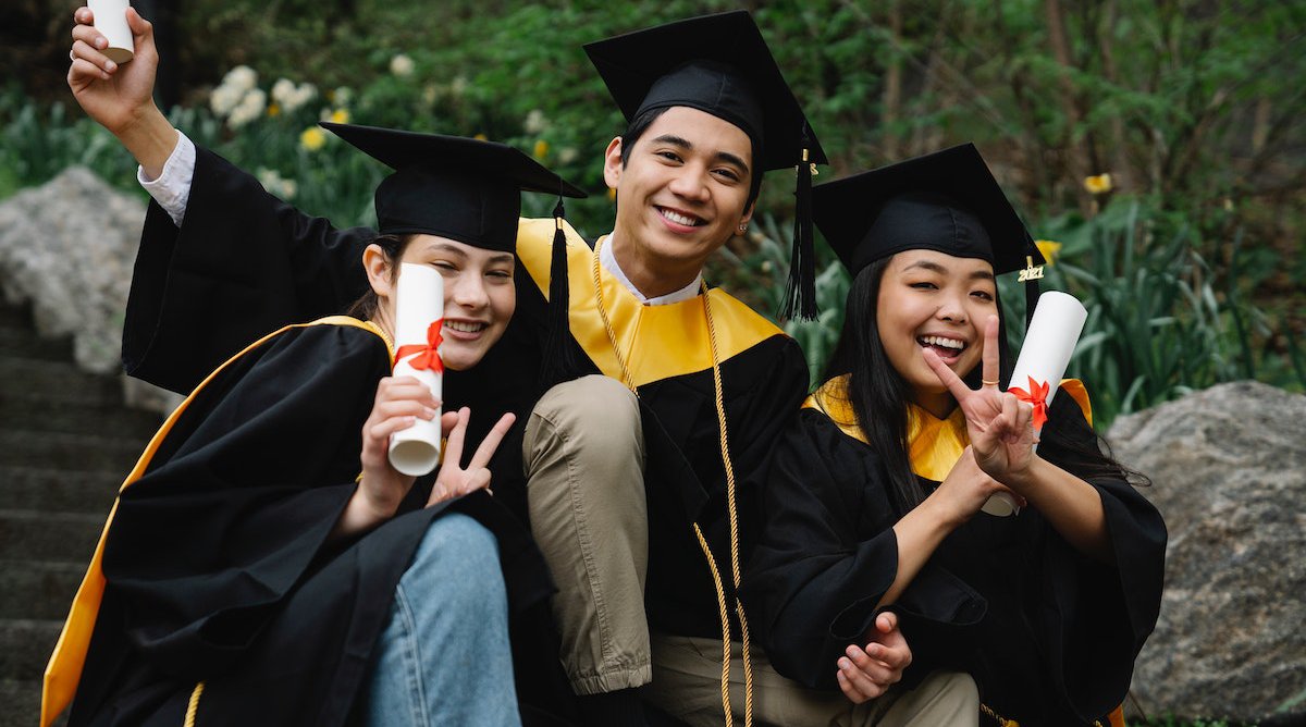 college students holding diplomas