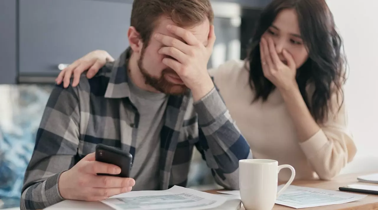 man holding head with woman laughing