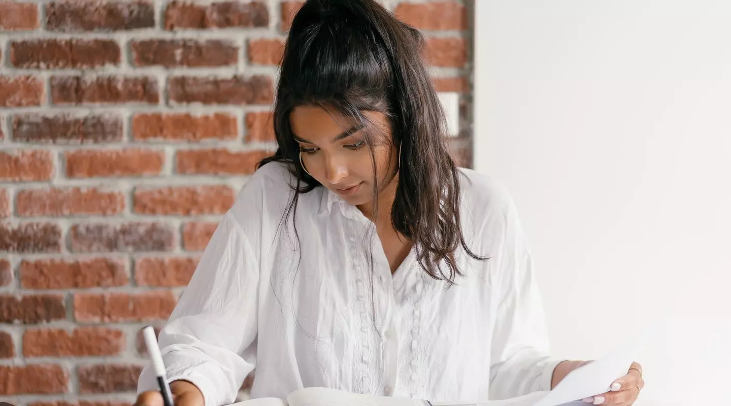woman reading and writing notes