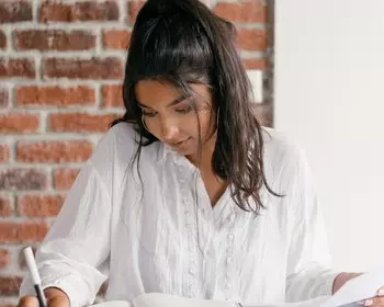 woman reading and writing notes