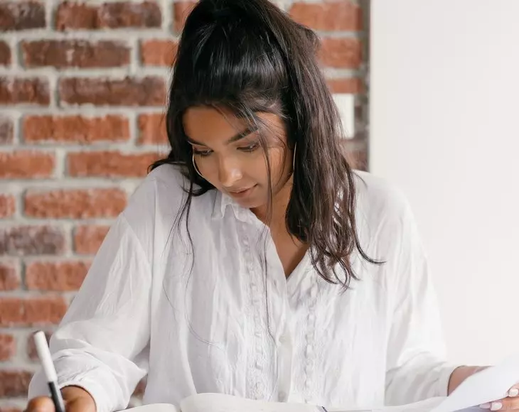 woman reading and writing notes