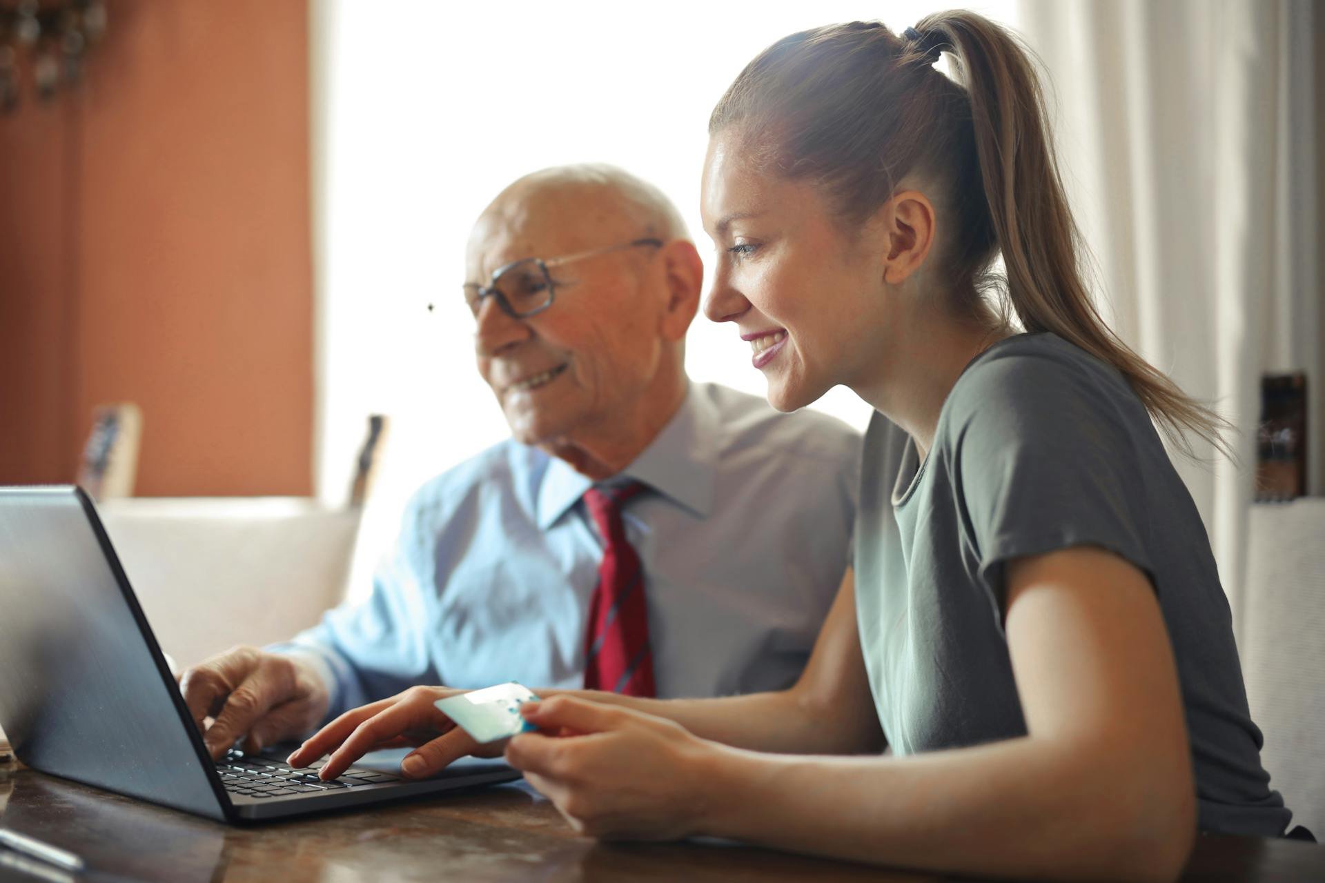 young woman and older man using laptop