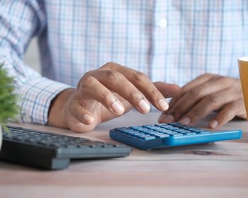 man typing on calculator