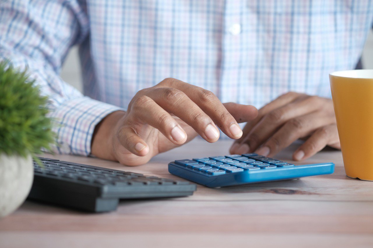 man typing on calculator