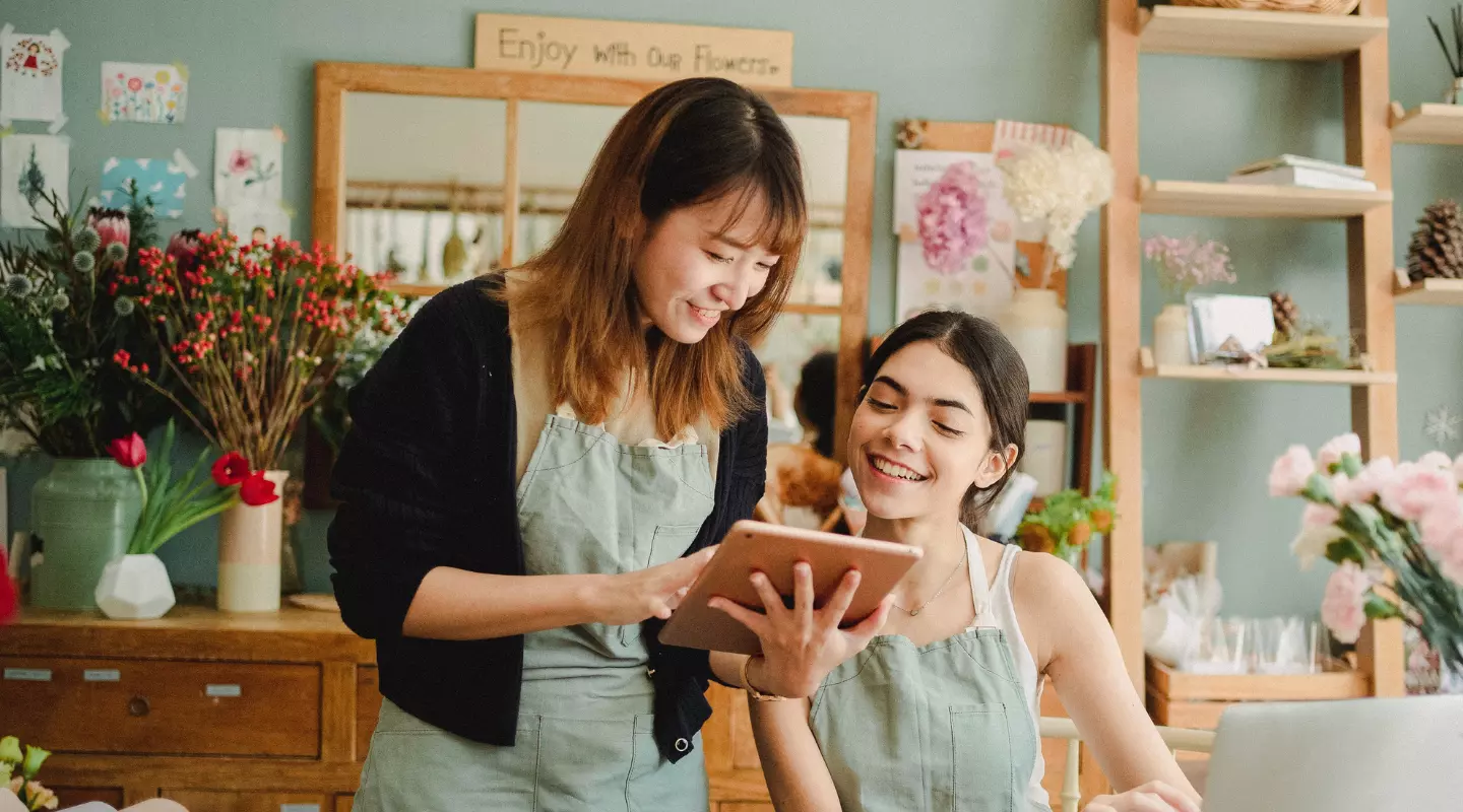 multiracial young women smiling at tablet
