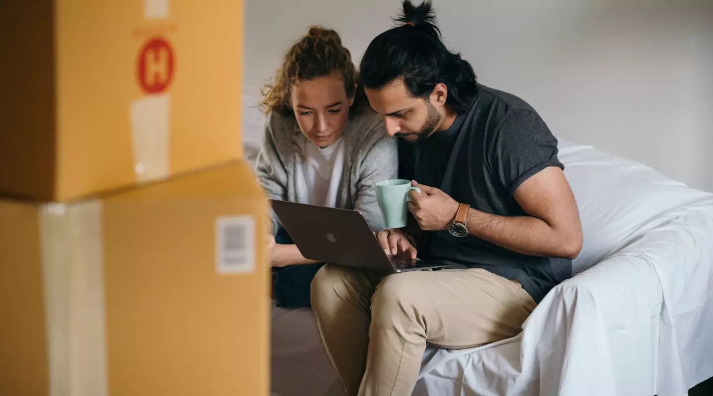 couple moving in looking at laptop